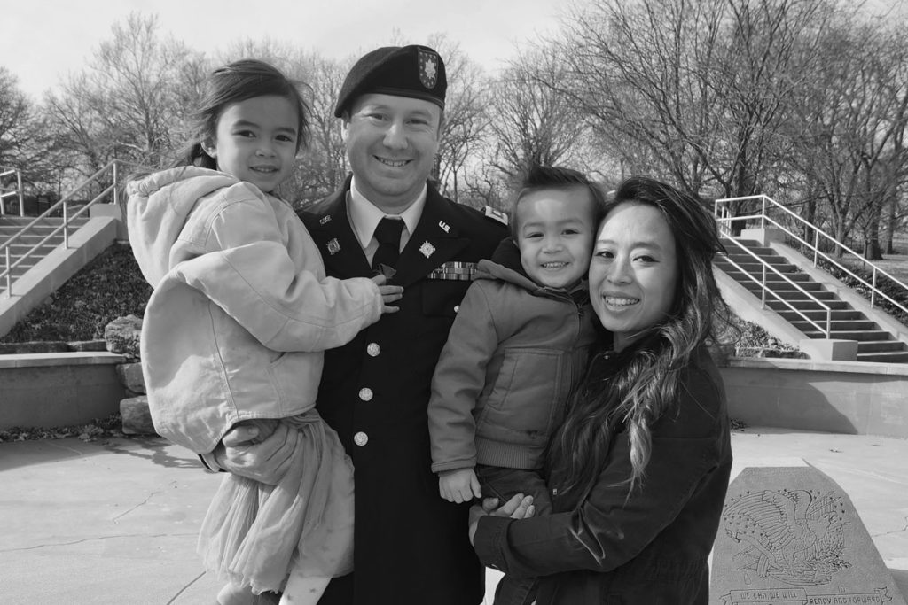 trang cline posing with her husband and two children